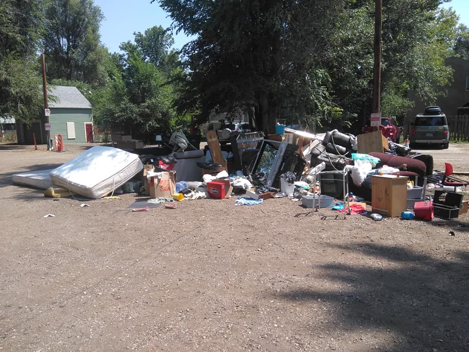 Large junk pile with mattress, furniture, and miscellaneous items before removal